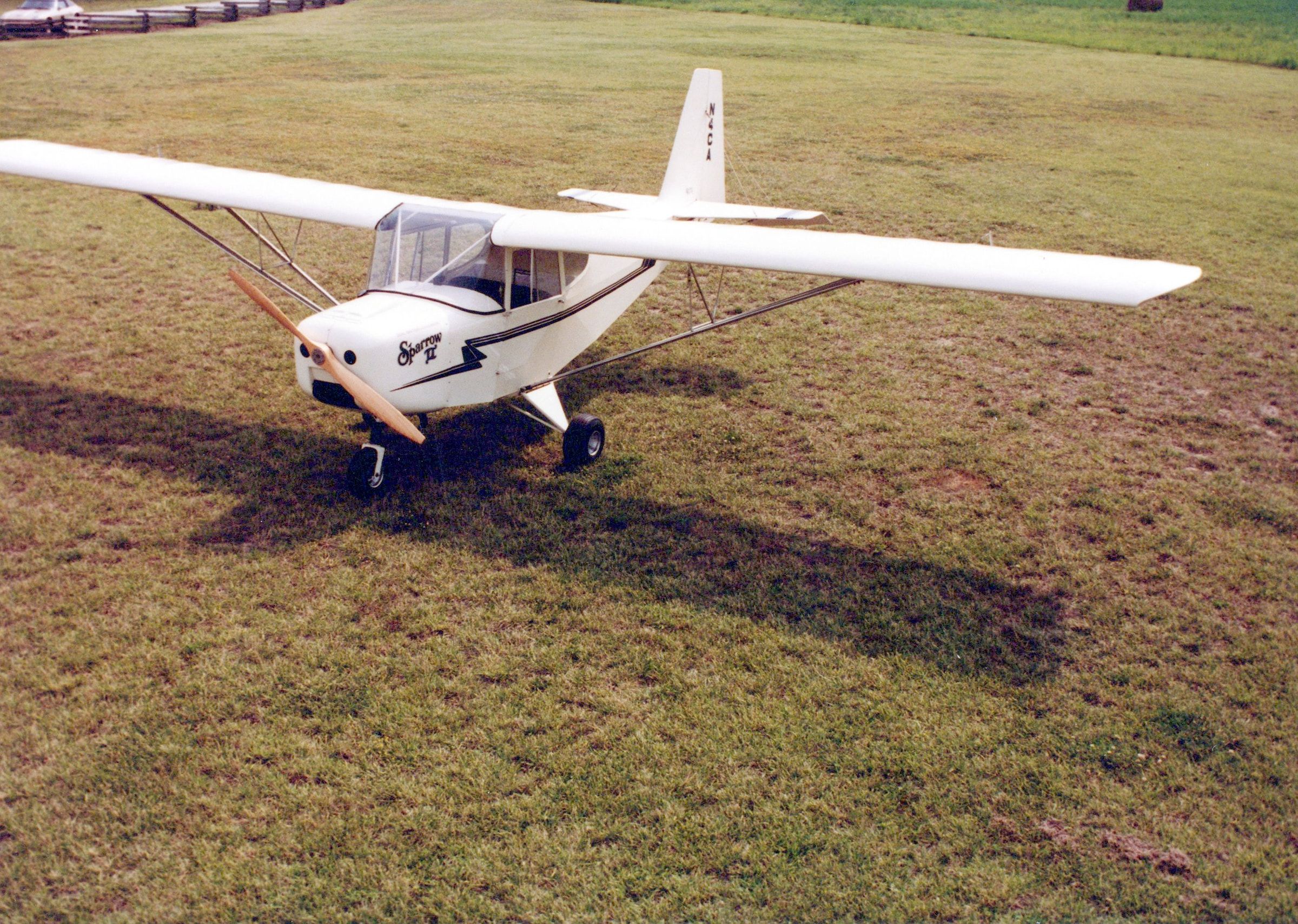 White Carlson Sparrow II parked on a grass field, seen from the front