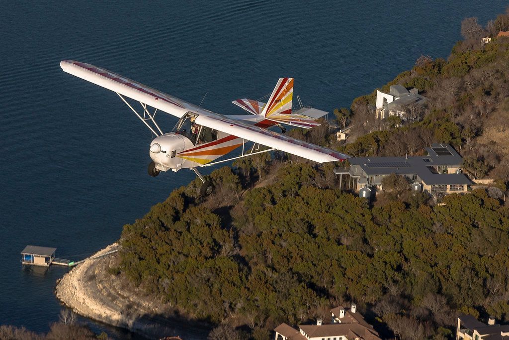 Carlson Sparrow Sport Special flying past lakeside homes