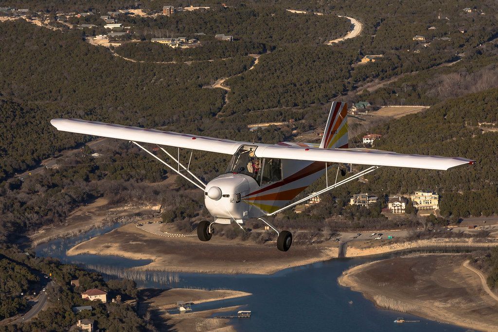 Carlson Sparrow Sport Special over a lake shoreline