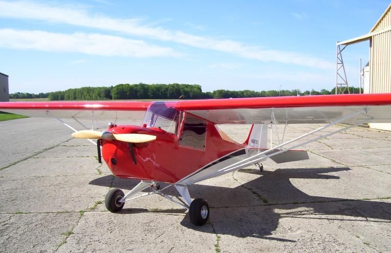 Front three-quarter view of a red and white Carlson Sparrow Sport Special on a ramp