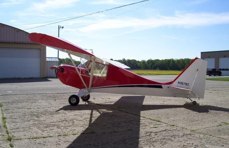 Side view of a red and white Carlson Sparrow Sport Special showing its tailwheel landing gear