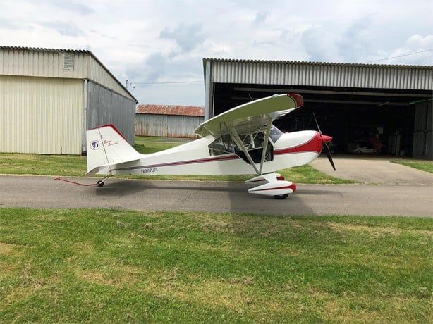 White and red Carlson Sparrow Sport Special with tailwheel landing gear outside a hangar