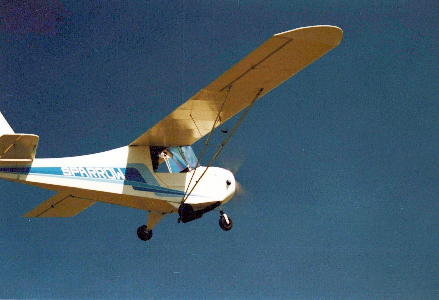 Carlson Sparrow Ultralight banking against a deep blue sky